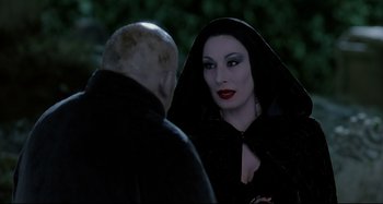 Movie still from “The Addams Family” (1991), directed by Barry Sonnenfeld – A man and a woman dressed as the evil queen; Close Up shot, Over the shoulder angle