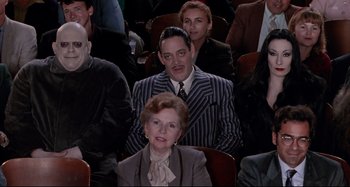 Movie still from “The Addams Family” (1991), directed by Barry Sonnenfeld – A group of people sitting in a room; Medium shot, High angle
