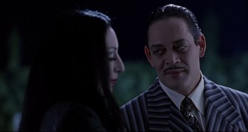 Movie still from “The Addams Family” (1991), directed by Barry Sonnenfeld – A man and a woman are looking at one another; Close Up shot, Over the shoulder angle