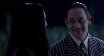 Movie still from “The Addams Family” (1991), directed by Barry Sonnenfeld – A man and a woman are talking to each other; Close Up shot, Over the shoulder angle