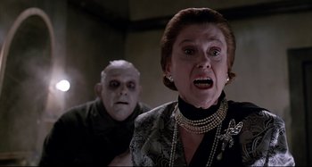 Movie still from “The Addams Family” (1991), directed by Barry Sonnenfeld – An older woman and an old man in a dark room; Close Up shot, Low angle