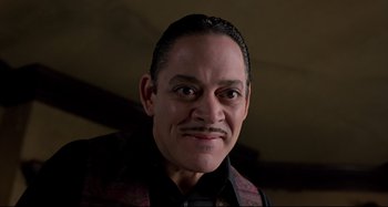 Movie still from “The Addams Family” (1991), directed by Barry Sonnenfeld – A person wearing a suit and tie; Close Up shot, Low angle