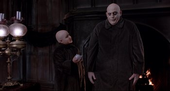 Movie still from “The Addams Family” (1991), directed by Barry Sonnenfeld – Two people dressed up as voldemort and harry potter; Medium shot, Low angle