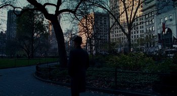 Movie still from “The Adjustment Bureau” (2011), directed by George Nolfi – A man standing in front of a tree in a park; Extreme Wide shot, Over the shoulder angle