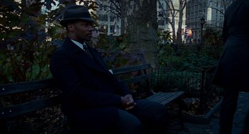 Movie still from “The Adjustment Bureau” (2011), directed by George Nolfi – A man sitting on top of a wooden park bench; Medium shot, Over the shoulder angle