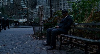Movie still from “The Adjustment Bureau” (2011), directed by George Nolfi – A man sitting on top of a wooden park bench; Wide shot, High angle