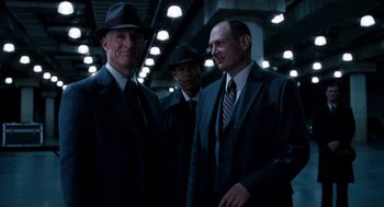 Movie still from “The Adjustment Bureau” (2011), directed by George Nolfi – A group of men standing next to each other in suits; Medium shot, Low angle