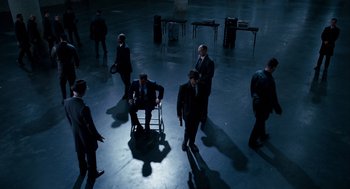 Movie still from “The Adjustment Bureau” (2011), directed by George Nolfi – A group of men in suits and ties standing in a room; Extreme Wide shot, High angle