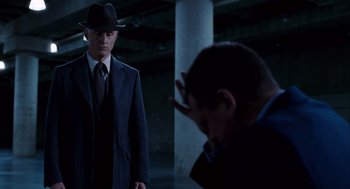 Movie still from “The Adjustment Bureau” (2011), directed by George Nolfi – A man wearing a suit and a hat is looking at another man in a suit; Medium shot, Over the shoulder angle