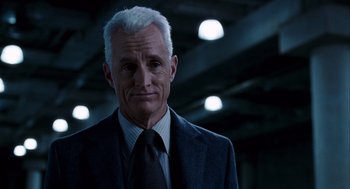 Movie still from “The Adjustment Bureau” (2011), directed by George Nolfi – A man in a suit and tie standing in front of lights; Close Up shot, Low angle