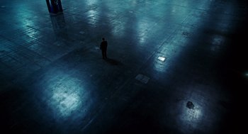 Movie still from “The Adjustment Bureau” (2011), directed by George Nolfi – A man standing in a dark room in a dark place; Extreme Wide shot, High angle