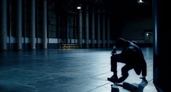 Movie still from “The Adjustment Bureau” (2011), directed by George Nolfi – A man sitting on the ground in an empty building; Wide shot, High angle