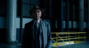 Movie still from “The Adjustment Bureau” (2011), directed by George Nolfi – An older man wearing a suit and hat; Medium shot, Low angle
