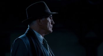 Movie still from “The Adjustment Bureau” (2011), directed by George Nolfi – An older man wearing a hat and a tie; Close Up shot, Low angle