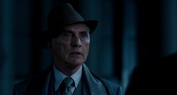 Movie still from “The Adjustment Bureau” (2011), directed by George Nolfi – An older man wearing a hat and a tie; Close Up shot, Low angle