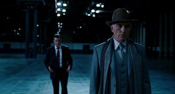Movie still from “The Adjustment Bureau” (2011), directed by George Nolfi – A man in a suit and a hat standing next to another man in a suit and a hat; Medium shot, Low angle
