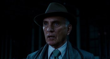 Movie still from “The Adjustment Bureau” (2011), directed by George Nolfi – An older man wearing a hat and a tie; Close Up shot, Low angle