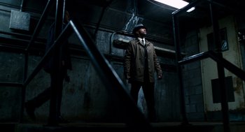 Movie still from “The Adjustment Bureau” (2011), directed by George Nolfi – A man standing in a dark room next to a woman; Wide shot, Low angle