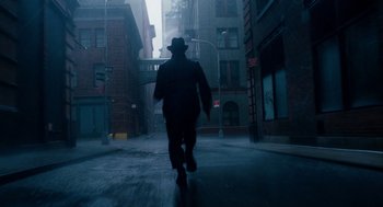 Movie still from “The Adjustment Bureau” (2011), directed by George Nolfi – A man walking down a street in the rain; Wide shot, Low angle