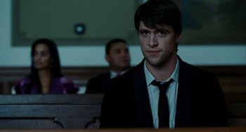 Movie still from “The Adjustment Bureau” (2011), directed by George Nolfi – A man in a suit and tie sitting in a courtroom; Close Up shot, Over the shoulder angle