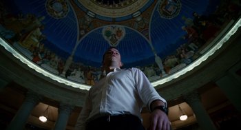 Movie still from “The Adjustment Bureau” (2011), directed by George Nolfi – A man standing in front of a ceiling with paintings on it; Wide shot, Low angle