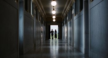 Movie still from “The Adjustment Bureau” (2011), directed by George Nolfi – Two people are walking down a long hallway; Extreme Wide shot, Low angle