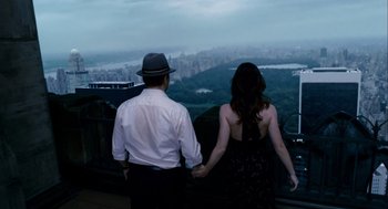 Movie still from “The Adjustment Bureau” (2011), directed by George Nolfi – A man and a woman holding hands while looking out over a city; Medium shot, Overhead angle