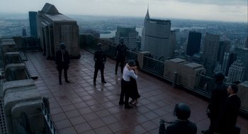 Movie still from “The Adjustment Bureau” (2011), directed by George Nolfi – A man and a woman kissing on the roof of a skyscraper; Wide shot, High angle