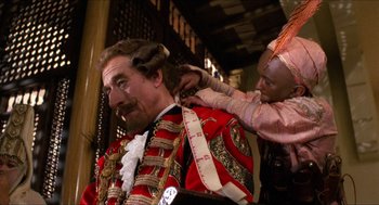 Movie still from “The Adventures of Baron Munchausen” (1988), directed by Terry Gilliam – A man is being shaved by another man; Medium shot, Over the shoulder angle