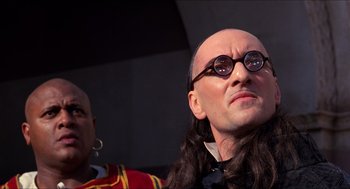 Movie still from “The Adventures of Baron Munchausen” (1988), directed by Terry Gilliam – A wax figure of a bald man with long black hair; Close Up shot, Low angle