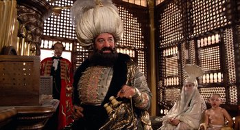 Movie still from “The Adventures of Baron Munchausen” (1988), directed by Terry Gilliam – A man dressed as a man with a beard is holding a sword; Medium shot, Low angle