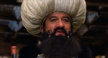 Movie still from “The Adventures of Baron Munchausen” (1988), directed by Terry Gilliam – A man with a beard and a large turban on his head; Close Up shot, Low angle