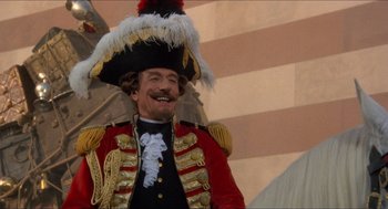 Movie still from “The Adventures of Baron Munchausen” (1988), directed by Terry Gilliam – A man in a red and black uniform and a hat; Medium shot, Low angle