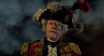 Movie still from “The Adventures of Baron Munchausen” (1988), directed by Terry Gilliam – An old man wearing a pirate costume and a hat; Close Up shot, Low angle
