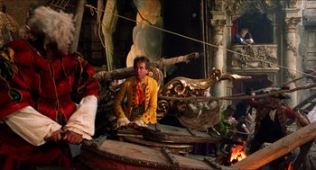 Movie still from “The Adventures of Baron Munchausen” (1988), directed by Terry Gilliam – A man sitting on top of a boat in a room; Wide shot, Low angle