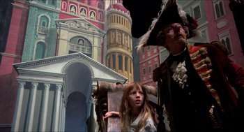 Movie still from “The Adventures of Baron Munchausen” (1988), directed by Terry Gilliam – A girl sitting in a chair in front of a building; Wide shot, Low angle