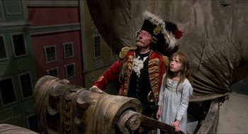 Movie still from “The Adventures of Baron Munchausen” (1988), directed by Terry Gilliam – A man and a little girl standing next to a cannon; Wide shot, Low angle