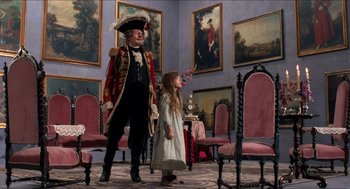 Movie still from “The Adventures of Baron Munchausen” (1988), directed by Terry Gilliam – A man and a little girl standing next to each other in a room; Wide shot, High angle