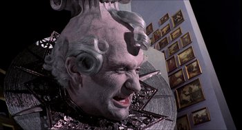 Movie still from “The Adventures of Baron Munchausen” (1988), directed by Terry Gilliam – A statue of an old man with a lot of hair on his head; Close Up shot, Low angle