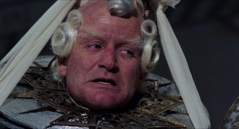 Movie still from “The Adventures of Baron Munchausen” (1988), directed by Terry Gilliam – An old man with a wig on his head; Close Up shot, High angle