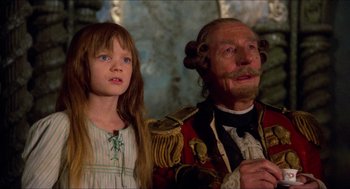 Movie still from “The Adventures of Baron Munchausen” (1988), directed by Terry Gilliam – A man and a little girl standing next to each other; Close Up shot, Low angle