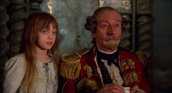 Movie still from “The Adventures of Baron Munchausen” (1988), directed by Terry Gilliam – A man and a little girl standing next to each other; Medium shot, Over the shoulder angle