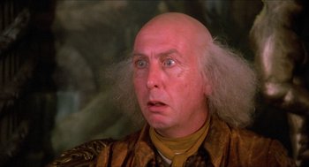 Movie still from “The Adventures of Baron Munchausen” (1988), directed by Terry Gilliam – An old man with a bald head is looking at the camera; Close Up shot, Over the shoulder angle