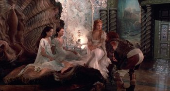 Movie still from “The Adventures of Baron Munchausen” (1988), directed by Terry Gilliam – A group of women sitting on a bed; Wide shot, High angle