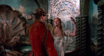 Movie still from “The Adventures of Baron Munchausen” (1988), directed by Terry Gilliam – A man and a woman standing next to each other in front of a mirror; Medium shot, Over the shoulder angle