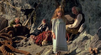 Movie still from “The Adventures of Baron Munchausen” (1988), directed by Terry Gilliam – A young girl standing in front of an older man and woman; Wide shot, High angle