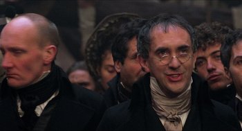 Movie still from “The Adventures of Baron Munchausen” (1988), directed by Terry Gilliam – A group of men in old - fashioned clothing; Close Up shot, Over the shoulder angle