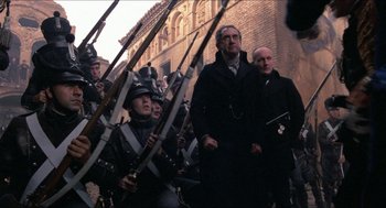 Movie still from “The Adventures of Baron Munchausen” (1988), directed by Terry Gilliam – A group of men in black coats and hats holding swords; Wide shot, Low angle