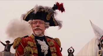 Movie still from “The Adventures of Baron Munchausen” (1988), directed by Terry Gilliam – An old man wearing a pirate hat with feathers on his head; Close Up shot, Low angle