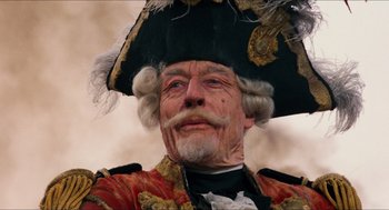 Movie still from “The Adventures of Baron Munchausen” (1988), directed by Terry Gilliam – An old man wearing a pirate costume and a hat; Close Up shot, Low angle